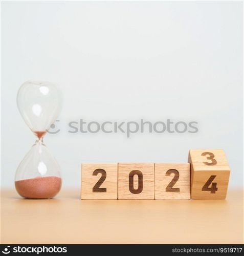 flipping block 2023 to 2024 text with hourglass on table. Resolution, time, plan, goal, motivation, reboot, countdown  and New Year holiday concepts