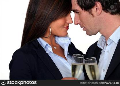 Flirtatious business couple drinking champagne
