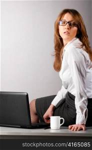 flirting sexy business woman is sitting on table in the office
