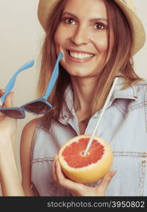 Flirty woman in hat hold sunglasses and grapefruit. Happy glad woman tourist in straw hat holding sunglasses and grapefruit citrus fruit. Seductive and flirty girl. Healthy diet food. Summer vacation holidays concept.