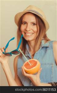 Flirty woman in hat hold sunglasses and grapefruit. Happy glad woman tourist in straw hat holding sunglasses and grapefruit citrus fruit. Seductive and flirty girl. Healthy diet food. Summer vacation holidays concept. Instagram filtered.
