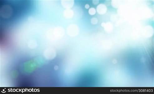 Floating defocused white particles on a blue background with light rays and lense flares