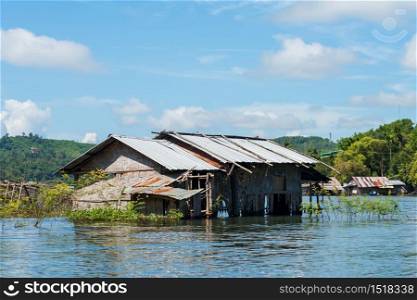 Floating houses at Song Kalia river with blue sky of sunny day in Sangkhlaburi, Kanchanaburi, Thailand. Famous travel destination.