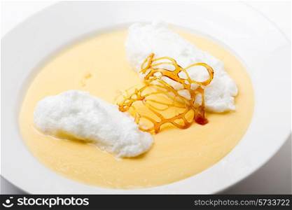 Floating islands, fluffy poached meringue on a lake of custard made from egg yolks, milk, sugar and vanilla, topped with a caramel framework. This is a traditional French farmhouse dessert.