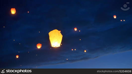 Floating paper lanterns on night sky