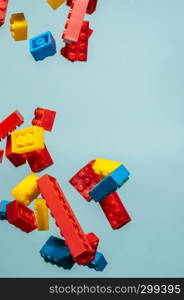 Floating Plastic geometric cubes in the air. Construction toys on geometric shapes falling down in motion. Blue pastel background. Children's toys. Circle geometric shapes on plastic bricks.