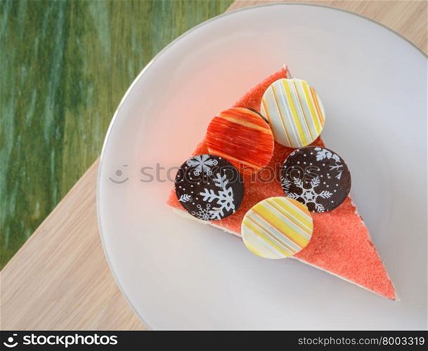 Floating Raspberry White Chocolate Mousse with chocolate coin topping on wooden table