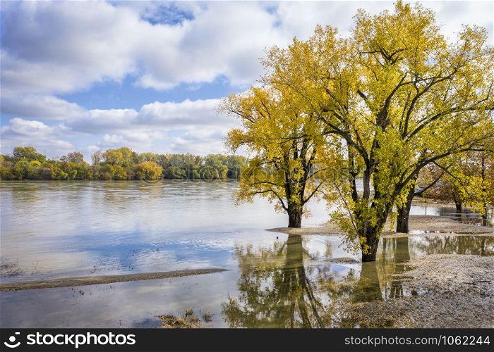 flooded Missouri River at Brownville, Nebraska, covering a boat ramp, fall colors scenery with cottonwood tress, aerial perspective