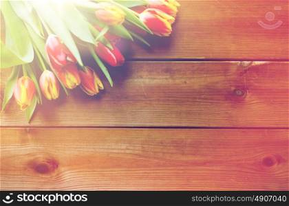 flora, gardening and plant concept - close up of tulip flowers on wooden table. close up of tulip flowers on wooden table