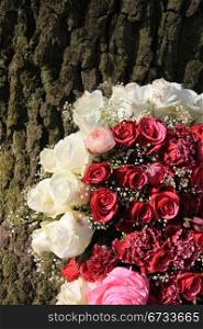 Floral arrangement of pink and white roses near a tree