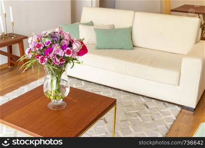 Floral arrangement of roses and limoniums decorating the living room of the house