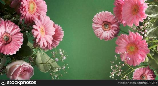 Floral background with pink gerbera flowers frame at green backdrop. Front view with copy space.
