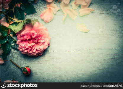 Floral background with pink roses flowers on turquoise shabby chic wood, top view, retro toned