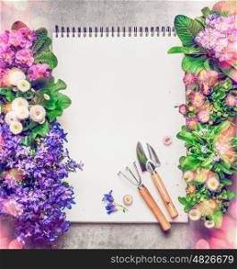Floral Gardening background with assortment of colorful garden flowers in pots , blank paper notebook and gardening tools, top view, frame