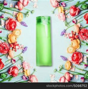Floral natural cosmetic product and beauty concept. Green Bottle with and flowers on shabby chic background, top view
