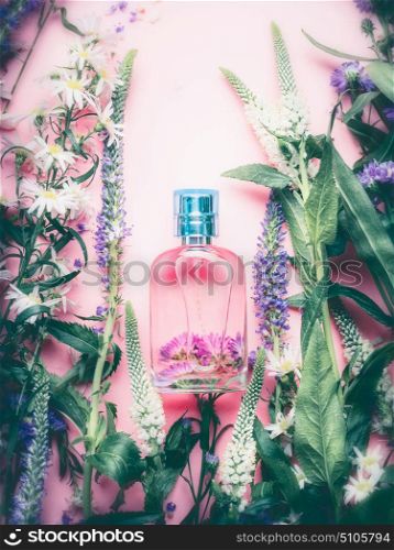Floral Perfume bottle with plants and flowers, top view. Perfumery, cosmetics, botanical fragrance concept.