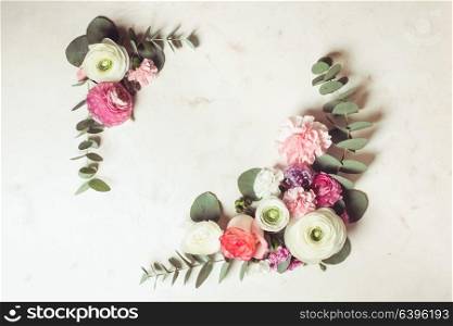 Floral round frame with eucalyptus branches and leaves, flat lay flowers, top view with copy space. Floral round frame