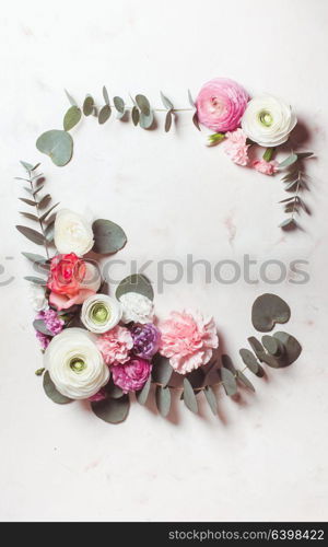 Floral round frame with eucalyptus branches and leaves, flat lay flowers, top view with copy space. Floral round frame