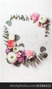 Floral round frame with eucalyptus branches and leaves, flat lay flowers, top view with copy space. Floral round frame