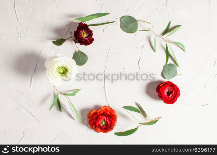 Floral round frame with eucalyptus branches and leaves on gray concrete background, flat lay, top view. Floral round frame