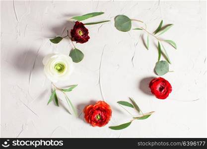 Floral round frame with eucalyptus branches and leaves on gray concrete background, flat lay, top view. Floral round frame