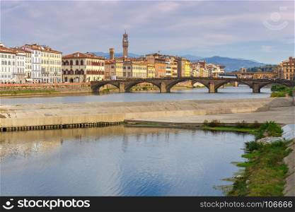 Florence. The city embankment along the Arno River.. Multicolored facades of traditional old Italian houses along the Arno river embankment. Florence. Italy.