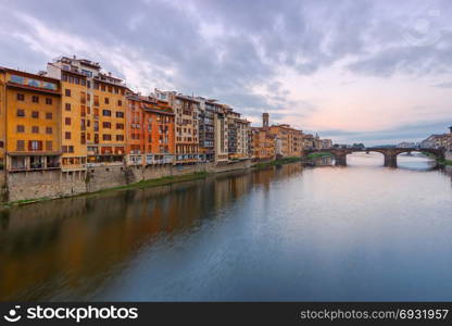Florence. The city embankment along the Arno River.. Multicolored facades of traditional old Italian houses along the Arno river embankment. Florence. Italy.