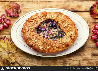 Florentine schiacchata with autumn grapes.Italian dessert on rustic wooden background. Schiacciata with grapes