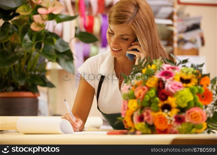 Florist at the phone with customers for aranging orders
