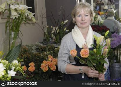 Florist holding a bouquet of flowers in her shop