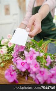 Florist holding card to accompany flowers