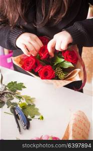 Florist making fashion bouquet of beautiful red roses. Florist making bouquet of red roses