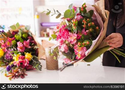 Florist making fashion bouquet of pink flowers. Florist making the bouquet with roses