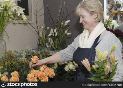 Florist picking flowers from her shop to make a bouquet