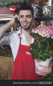 Florist stands on mobile phone with hydrangea