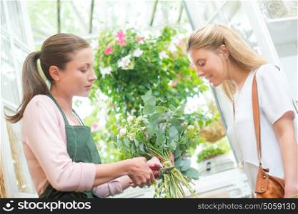 Florist trimming stems of flowers for customer