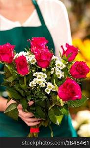 Florist woman holding red roses bouquet hands flower shop