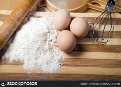 Flour and eggs on a wooden board