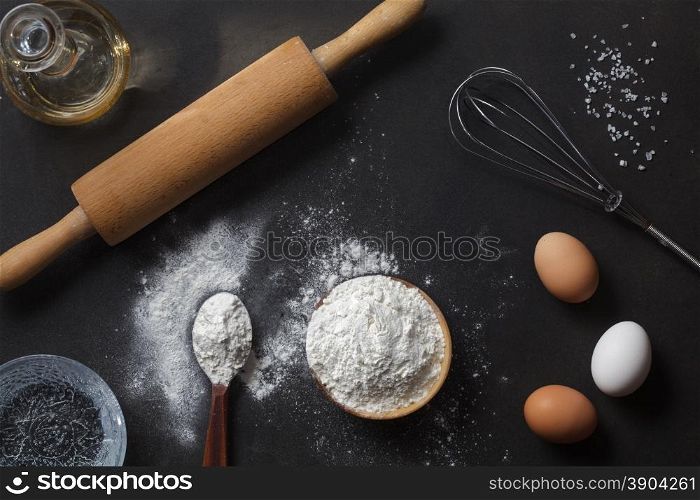 flour and ingredients on black table. flour and ingredients on black table. Top view