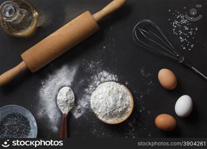 flour and ingredients on black table. flour and ingredients on black table. Top view