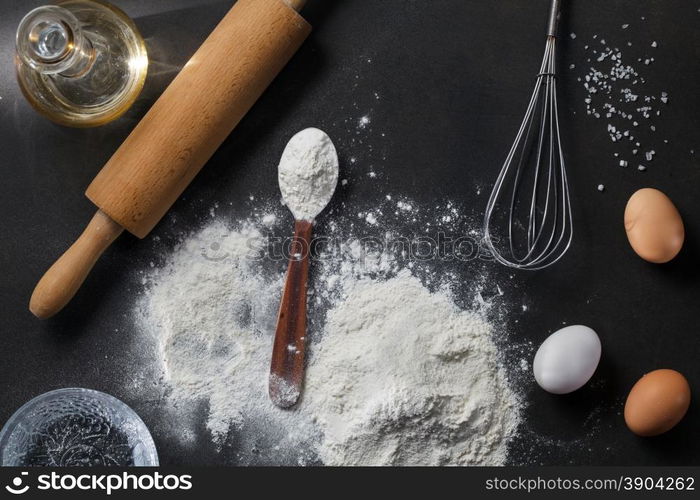 flour and ingredients on black table. flour and ingredients on black table. Top view