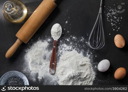 flour and ingredients on black table. flour and ingredients on black table. Top view