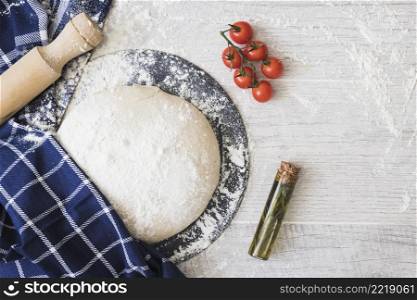 flour dusted dough bread cherry tomatoes rosemary rolling pins wooden plank