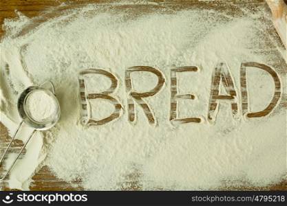 Flour on the table with writted word BREAD