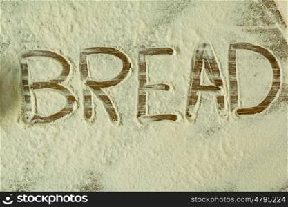Flour on the table with writted word BREAD