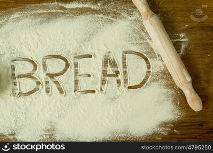 Flour on the table with writted word BREAD