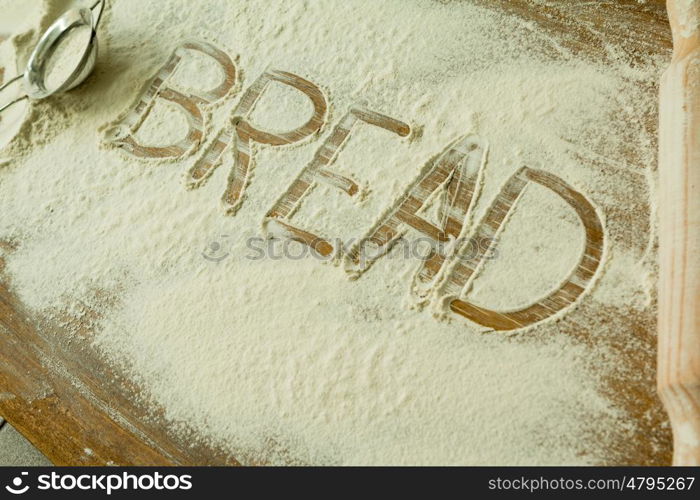 Flour on the table with writted word BREAD