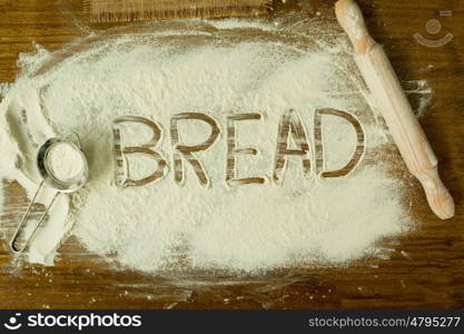 Flour on the table with writted word BREAD