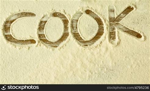 Flour on the table with writted word COOK