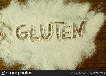 Flour on the table with writted word GLUTEN